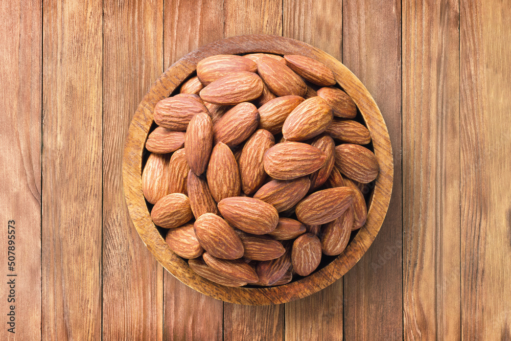 almond nuts peeled roasted in bowl on wooden table background, top view. organic vegetarian food. almond nuts peeled roasted in bowl on wooden table background, top view. organic vegetarian food.