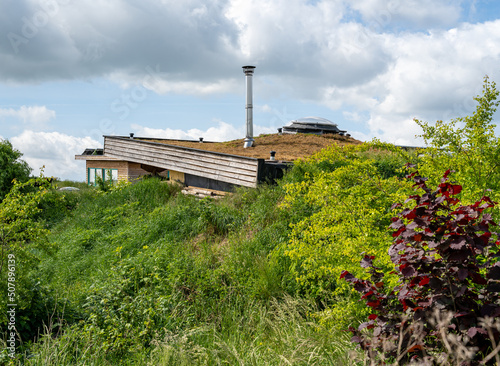 Roof of modern self sufficient earth house with soil against the walls photo