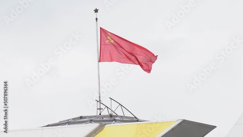 Historical concept. On the roof of the building, the flag of the Soviet Union flutters in the wind. photo