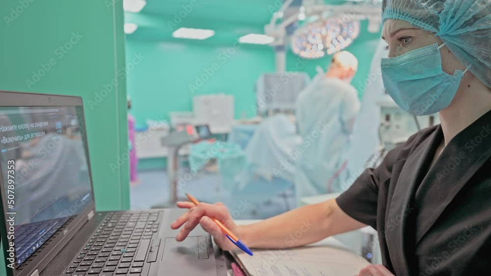 The operating nurse monitors the progress of the operation The operating nurse monitors the progress of the operation