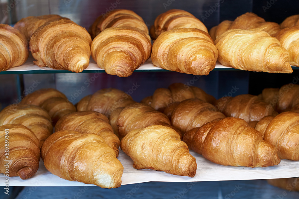 Lots of fresh french croissants on the store shelf