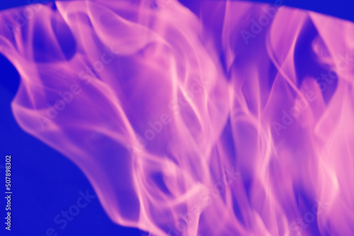 Abstract pink-violet reflections of light, flame, smoke, blurred on a blue background. Bright colored background.
