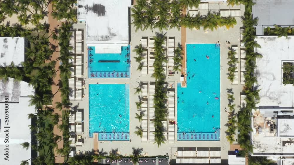 Aerial view from drone on poolside with swimming pool, umbrellas and sunbeds. Travel destination. Summer vacations Aerial view from drone on poolside with swimming pool, umbrellas and sunbeds. Travel destination. Summer vacations