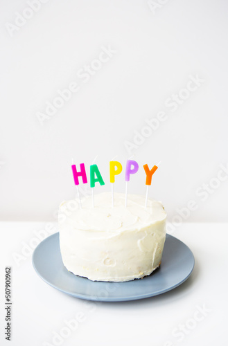 Birthday cake, on a creamy sponge cake the inscription happiness. The concept of the holiday and birthday surprise.