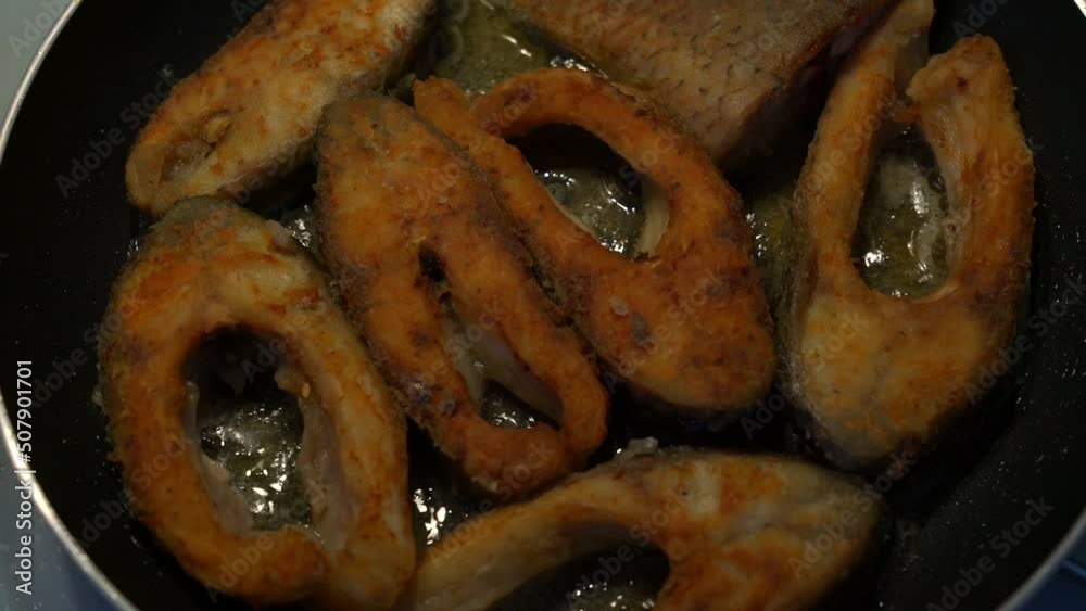 Sliced fresh fish meat are roasting in cooking oil at fried pan. Homemade eating concept. Sliced fresh fish meat are roasting in cooking oil at fried pan. Homemade eating concept.