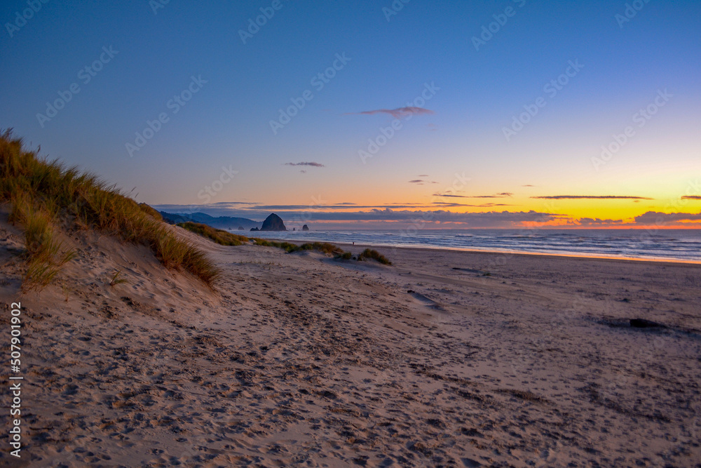 Sunset at Canon Beach with Haystack Rock and sun going down, Ecola beach.