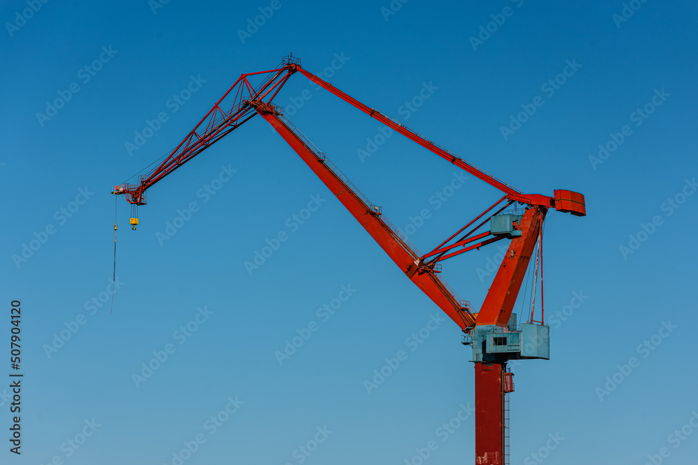 Arm and steering house of an old red yard crane.