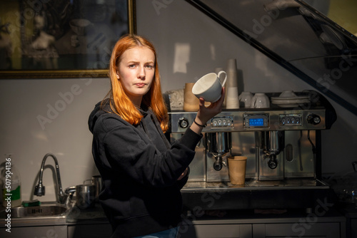 Barista girl near the coffee machine.