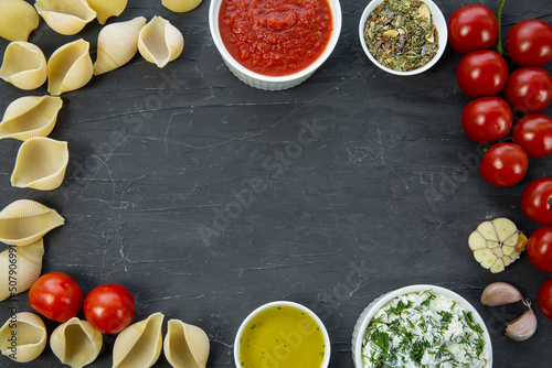 Food ingredients frame: italian pasta conchiglie, tomatoes, ricotta, sauce, copy space, space for text. .
