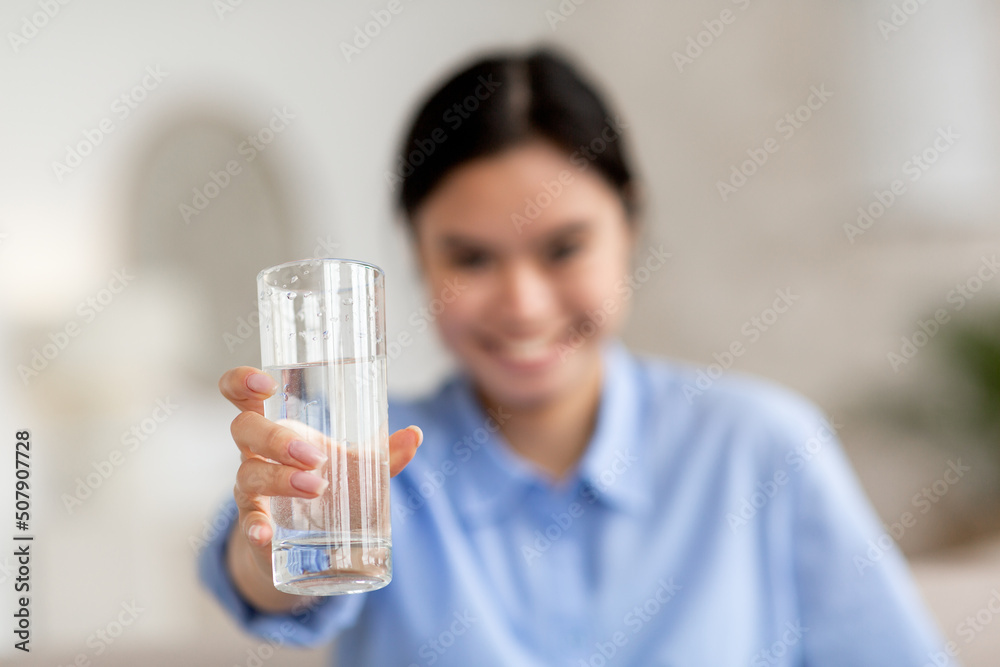 Selective focus on glass of water in asian woman hand