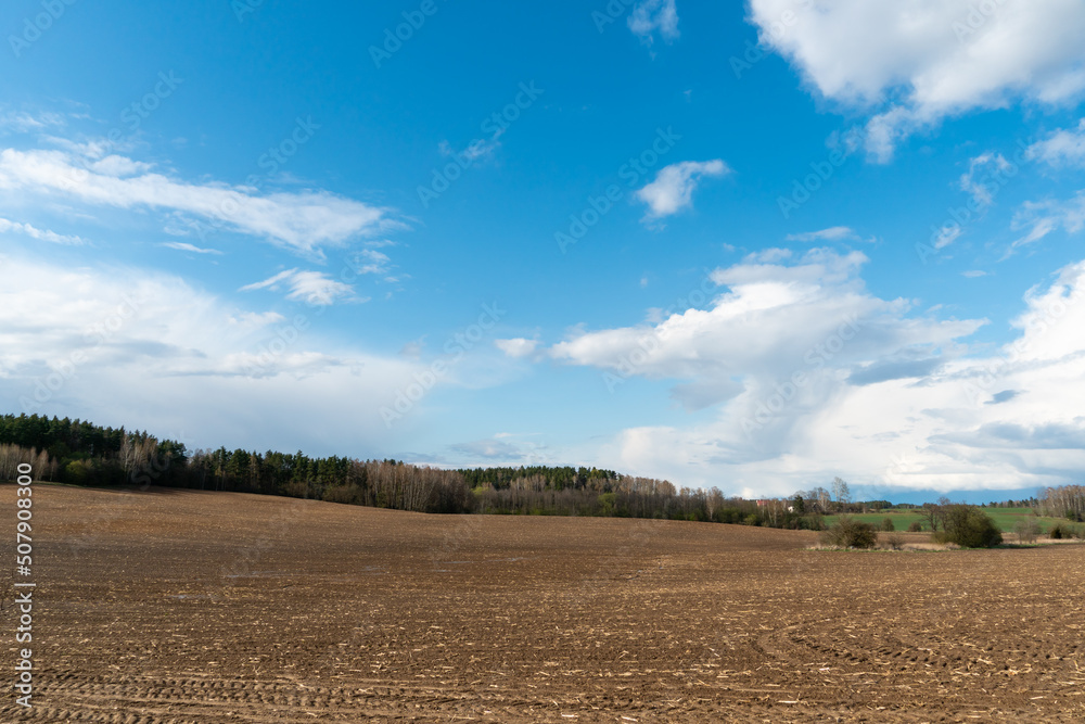 Rows of soil before planting. Drawing of furrows on a plowed field prepared for spring sowing of agricultural crops. View of the land prepared for planting and growing crops.