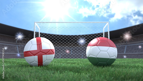 Two soccer balls in flags colors on stadium blurred background. England and Hungary. 3d image