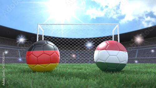 Two soccer balls in flags colors on stadium blurred background. Germany and Hungary. 3d image