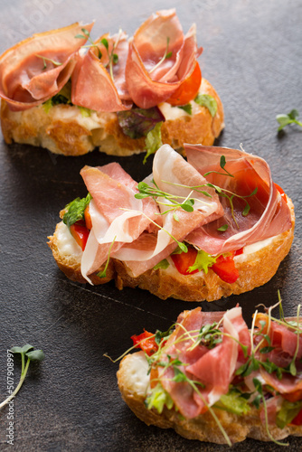 Baguette slices with bacon, red pepper, watercress and cream cheese