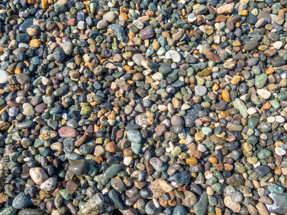Background from multicolored pebbles. Pebble coast. Stone beach. Stone pattern. Background from multicolored pebbles. Pebble coast. Stone beach. Stone pattern.