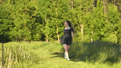 A young girl runs in a meadow on a warm summer evening.