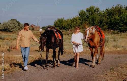 Loving couple with two horses on ranch at summer