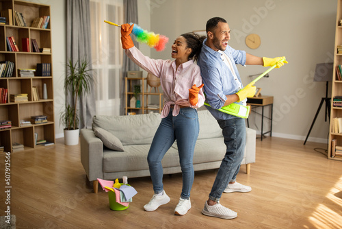 African Couple Cleaning House And Having Fun Singing At Home photo