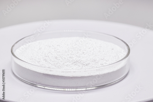 Petri dish with powdered Benzoyl Peroxide, used in the preparation of cream, lotion or gel in the treatment of acne and mild and moderate forms of dermatitis. Isolated white background, copy space photo