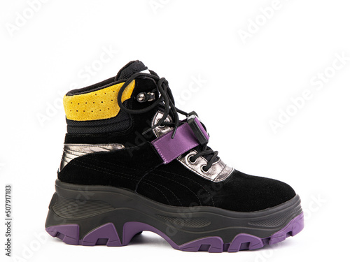 Women's black, purple and yellow hiking boots isolated white background. Right side view. Fashion shoes. Photoshoot for shoe shop concept.