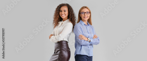 Beautiful businesswomen on grey background