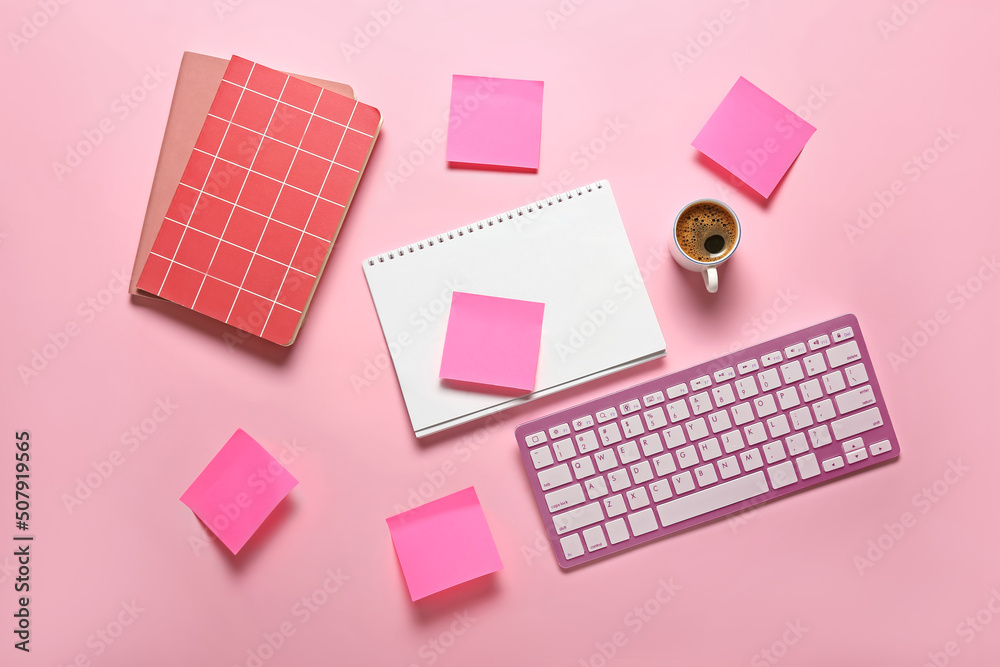 Notebooks, note papers, PC keyboard and cup of coffee on pink background Notebooks, note papers, PC keyboard and cup of coffee on pink background