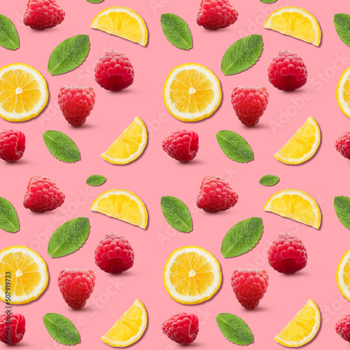 Fototapeta Naklejka Na Ścianę i Meble -  Many ripe raspberries, lemon slices and mint leaves on pink background. Pattern for design