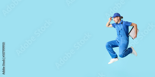 Jumping male worker on blue background with space for text