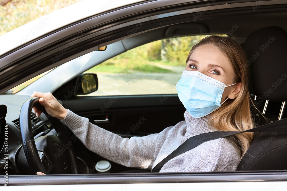 Female driver wearing medical mask in car Female driver wearing medical mask in car