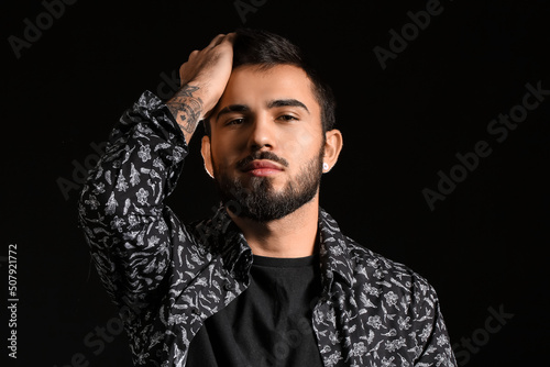 Fashionable bearded man adj...