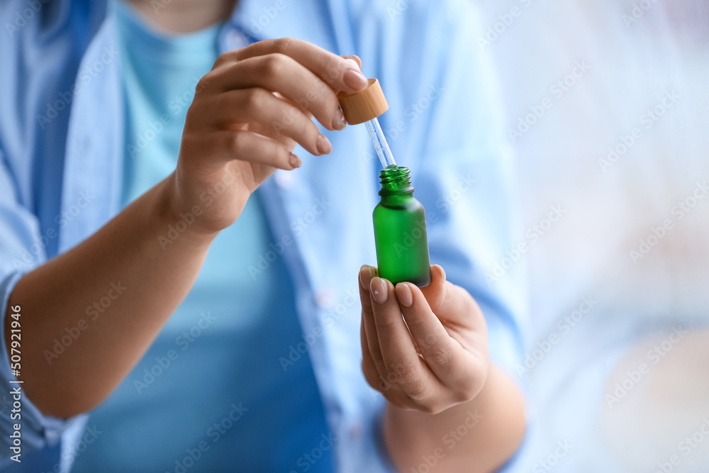 Woman holding bottle of serum, closeup Woman holding bottle of serum, closeup