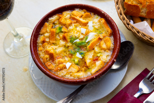 Fresh and light traditional Cojondongo from Extremadura with very rich taste prepared of chopped egg, pepper, tomatoes and soaked bread with dressing garlic, olive oil, vinegar and water in clay bowl