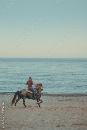 ride a horse at the beach at sunset