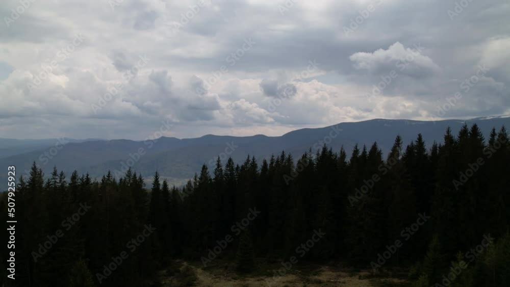 Timelapse of cloudy weather in mountains. Stormy clouds moving fast in Dramatic sky over the coniferous forest. Footage Timelapse Dark sky and black cloud.  
