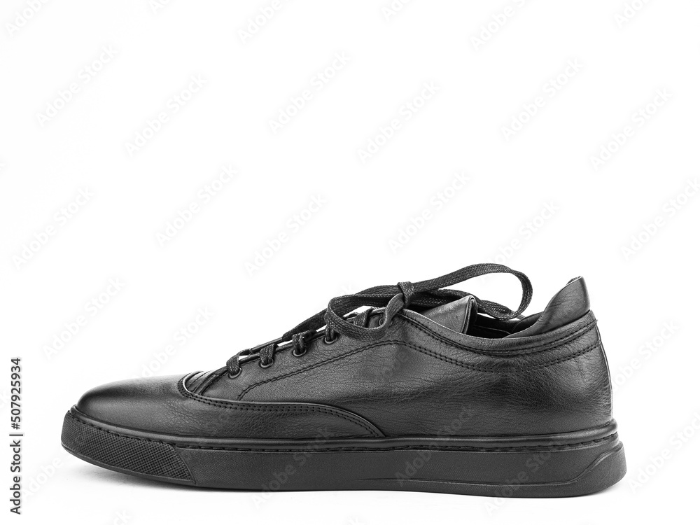 Black leather classic sneakers with laces. Casual men's style. Black rubber soles. Isolated close-up on white background. Left side view.