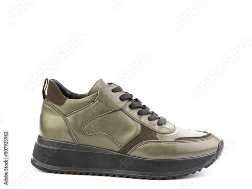Green leather classic sneakers with laces. Casual men's style. Black rubber soles. Isolated close-up on white background. Right side view.