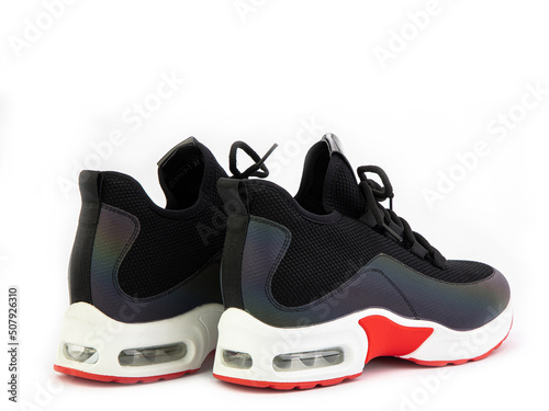 Women's black and orange hiking boots isolated white background. Back side view. Fashion shoes. Photoshoot for shoe shop concept.