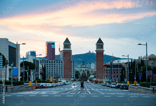 Scenic view of Avinguda de la Reina Maria Cristina in Barcelona leading to Placa de Espana with two Venetian Towers on either side of avenue on background of colorful sky at sunset in summer, Spain photo