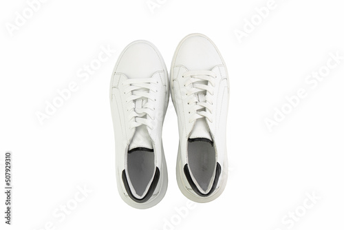 White leather sneakers. Casual women's style. White lacing and white rubber soles. Isolated close-up on white background. Top view. Fashion shoes © MONIUK ANDRII