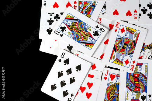 bunch of playing cards of different colors on a black background