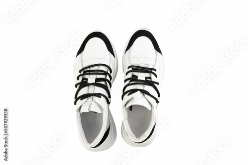 Obraz na płótnie White leather sneakers. Casual women's style. White lacing and white rubber soles. Isolated close-up on white background. Top view. Fashion shoes w salonie