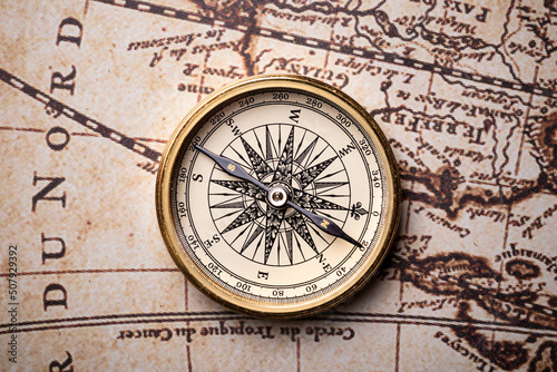 Old golden compass on the antique and vintage mundi map.  photo