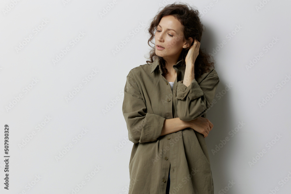 Frustrated pensive curly beautiful woman in casual khaki green shirt thinks about abusive relationships looks aside posing isolated on white background. People Emotions Lifestyle concept. Copy space Frustrated pensive curly beautiful woman in casual khaki green shirt thinks about abusive relationships looks aside posing isolated on white background. People Emotions Lifestyle concept. Copy space