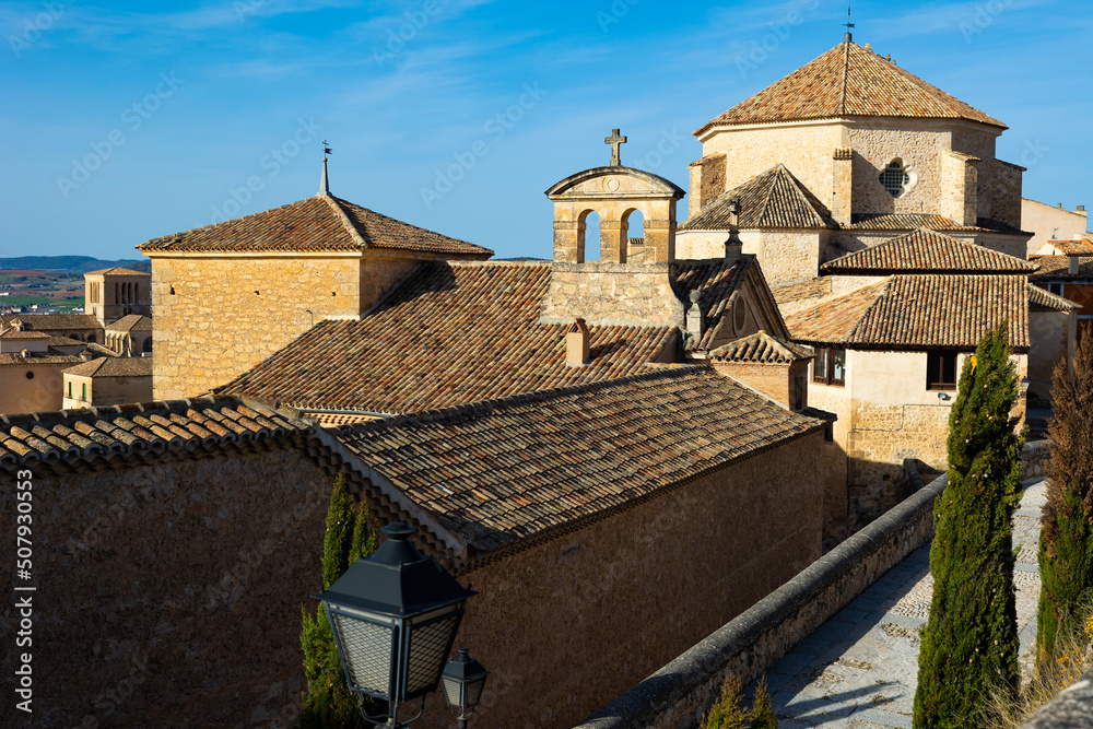Scenic view of Cuenca cityscape on sunny spring day overlooking medieval Church of San Pedro and former Carmelite monastery, Byzantine style stone buildings with brown tiled roof, Spain