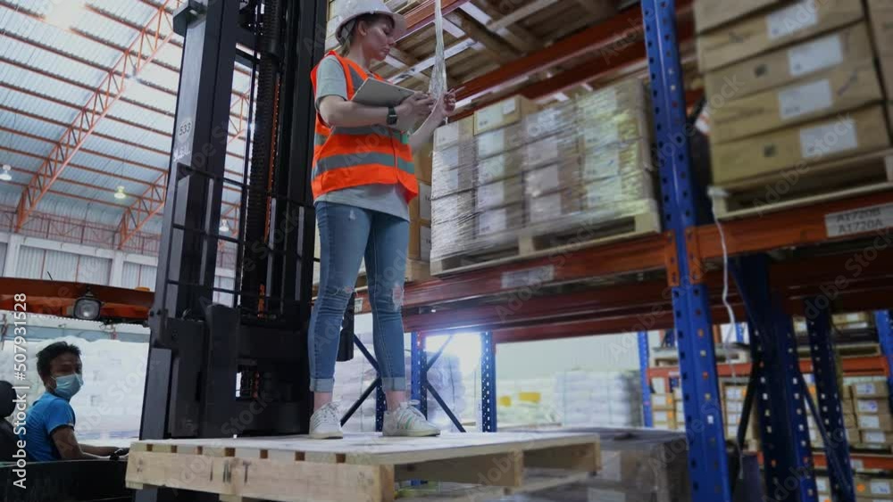 Business concept of 4k Resolution. An employee is checking the goods with a tablet in the warehouse.