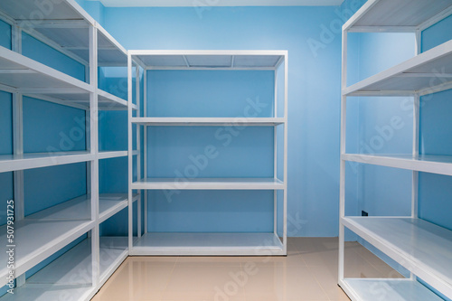 Empty white shelves in blue storage room