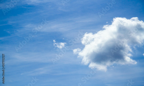 Summer sky. Cumulus clouds on a blue background. Partly cloudy.