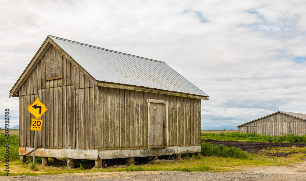 An old wooden barn in a farm in overcast day in Canada. An old wooden barn in a farm in overcast day in Canada.