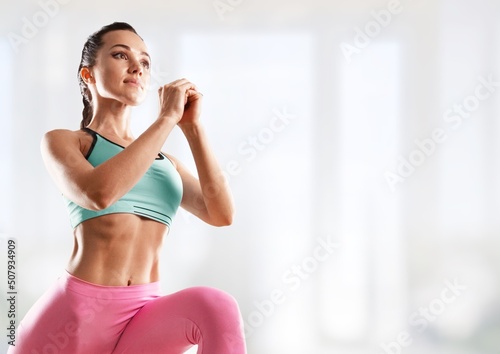 Portrait of sportswoman stretching body, exercising, doing fitness and smiling,