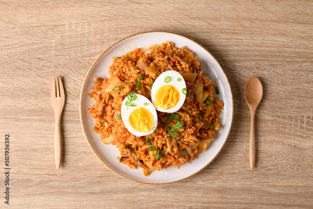 Korean kimchi fried rice with boiled egg on wooden table Korean kimchi fried rice with boiled egg on wooden table